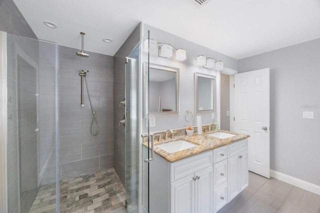 bathroom featuring a tile shower and vanity