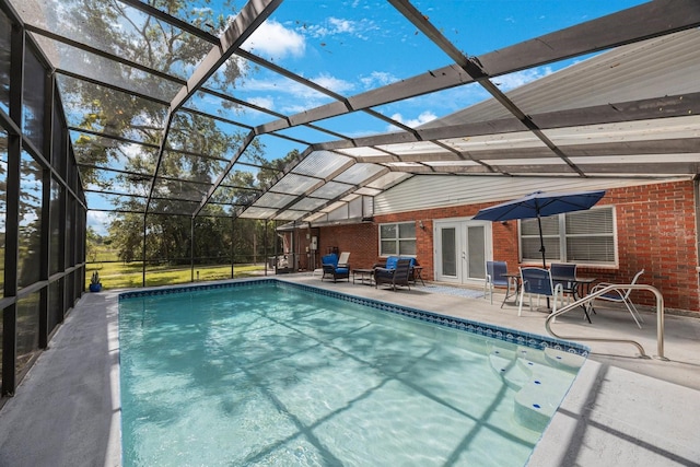 view of pool featuring french doors, glass enclosure, and a patio area