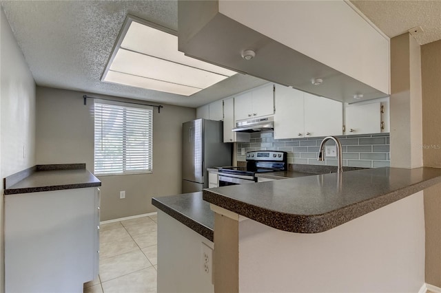 kitchen with a textured ceiling, light tile patterned floors, stainless steel appliances, kitchen peninsula, and white cabinets