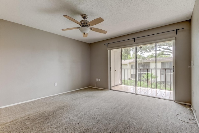 carpeted spare room featuring a textured ceiling and ceiling fan