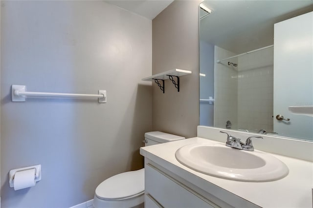 bathroom featuring vanity, toilet, and a tile shower