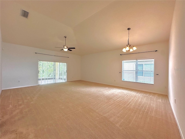 carpeted empty room featuring lofted ceiling and ceiling fan with notable chandelier