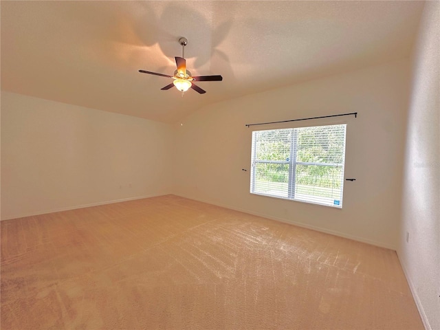 carpeted empty room featuring vaulted ceiling and ceiling fan