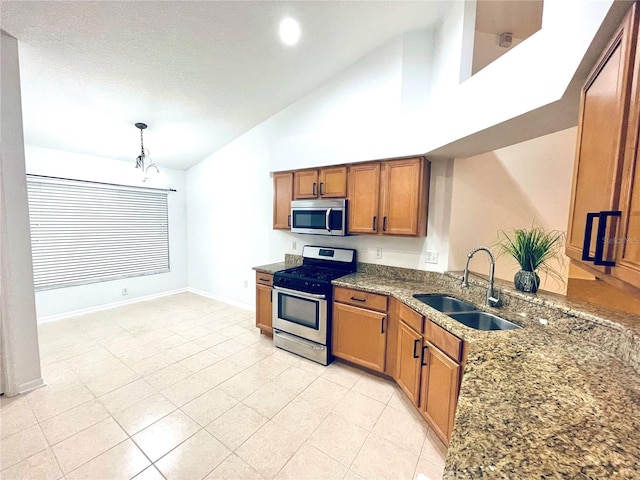 kitchen with appliances with stainless steel finishes, sink, hanging light fixtures, high vaulted ceiling, and a chandelier