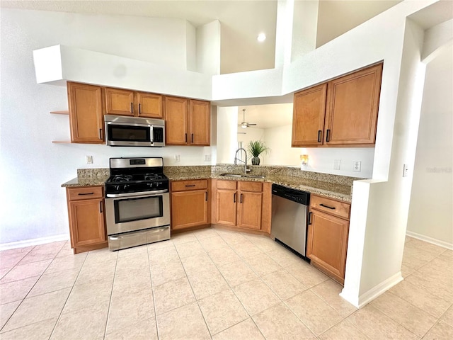 kitchen with a sink, open shelves, brown cabinetry, and stainless steel appliances