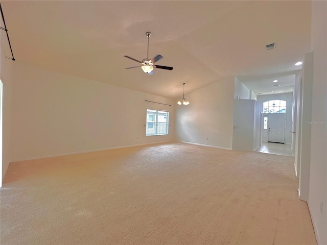 spare room featuring visible vents, light carpet, ceiling fan with notable chandelier, baseboards, and lofted ceiling