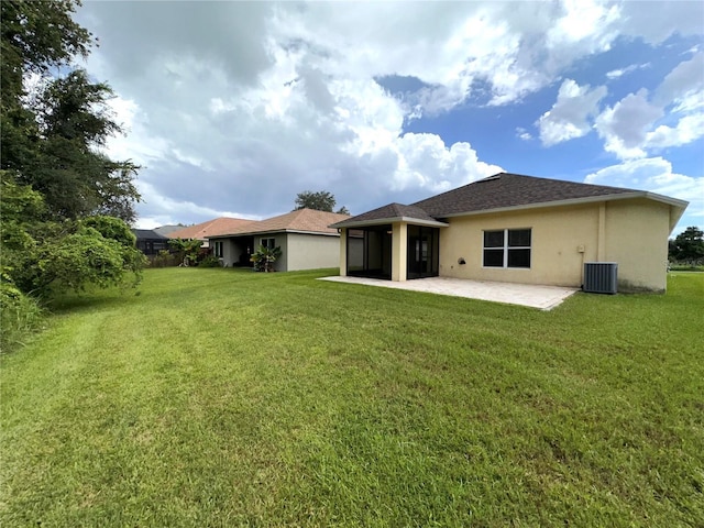 rear view of property featuring a patio area, central air condition unit, a lawn, and stucco siding