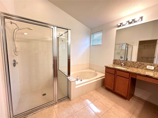 full bathroom featuring vanity, a shower stall, vaulted ceiling, a textured ceiling, and a bath