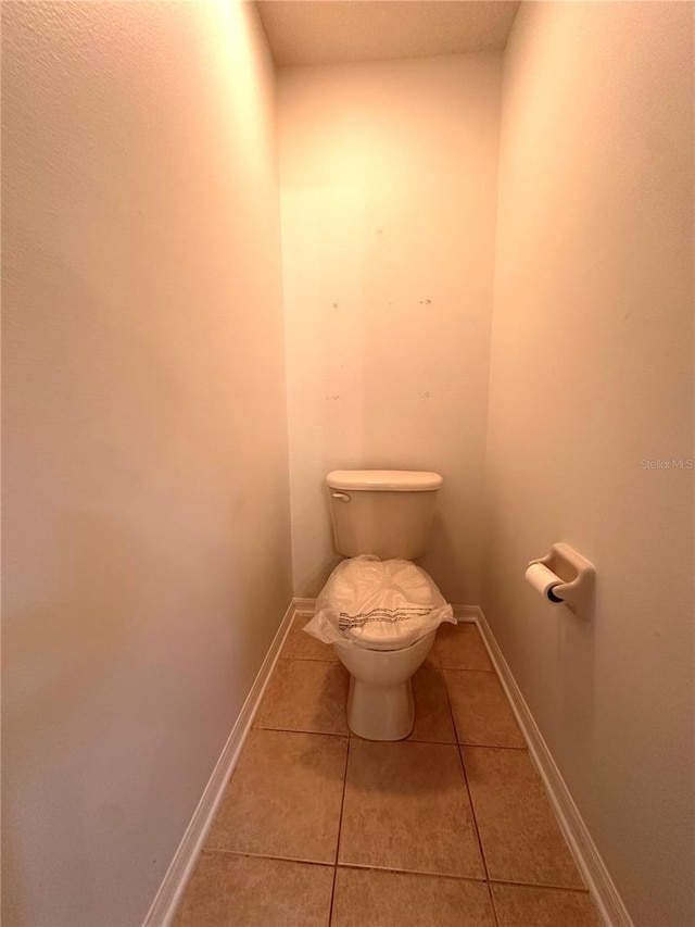 bathroom featuring tile patterned floors, toilet, and baseboards