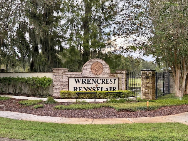 community / neighborhood sign featuring fence