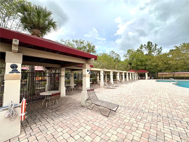 view of patio featuring a community pool and fence