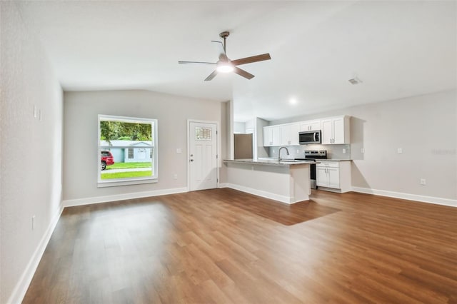 unfurnished living room with vaulted ceiling, sink, ceiling fan, and light hardwood / wood-style floors