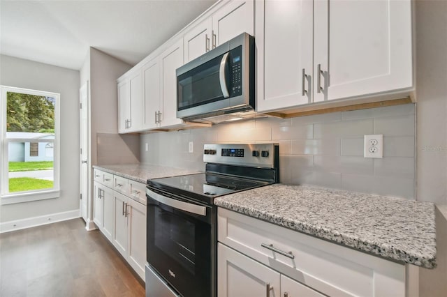 kitchen featuring light stone countertops, dark hardwood / wood-style flooring, tasteful backsplash, stainless steel appliances, and white cabinets