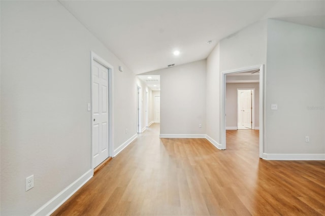 spare room with lofted ceiling and light hardwood / wood-style flooring