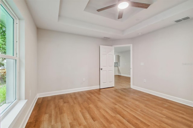 unfurnished room featuring a wealth of natural light, ceiling fan, and light hardwood / wood-style floors