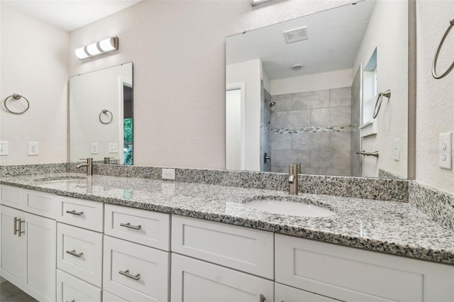 bathroom featuring vanity and a tile shower