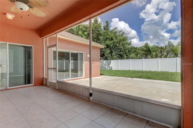 unfurnished sunroom featuring ceiling fan