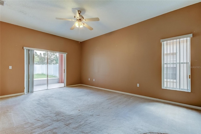 carpeted empty room with ceiling fan and a textured ceiling