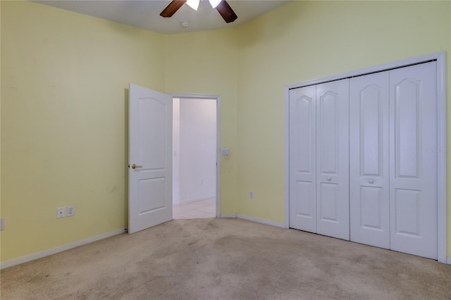 unfurnished bedroom featuring light carpet, a closet, and ceiling fan