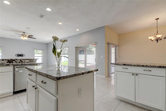 kitchen featuring dishwasher, ceiling fan with notable chandelier, white cabinets, hanging light fixtures, and a kitchen island