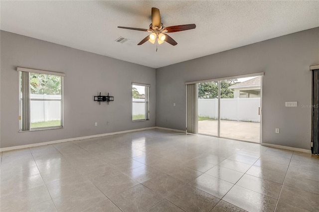 unfurnished room featuring ceiling fan, a textured ceiling, and light tile patterned flooring