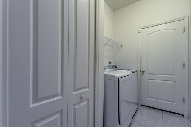 laundry area featuring light tile patterned flooring and washer and clothes dryer