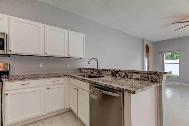 kitchen featuring kitchen peninsula, light stone counters, ceiling fan, and appliances with stainless steel finishes