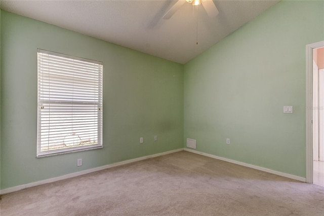 empty room featuring light carpet, lofted ceiling, and ceiling fan