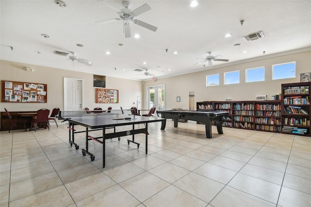 game room with a textured ceiling, light tile patterned floors, ceiling fan, and billiards