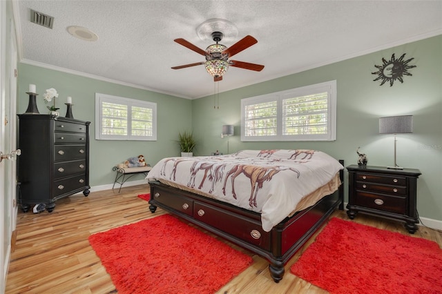 bedroom featuring multiple windows, ceiling fan, a textured ceiling, and light hardwood / wood-style flooring