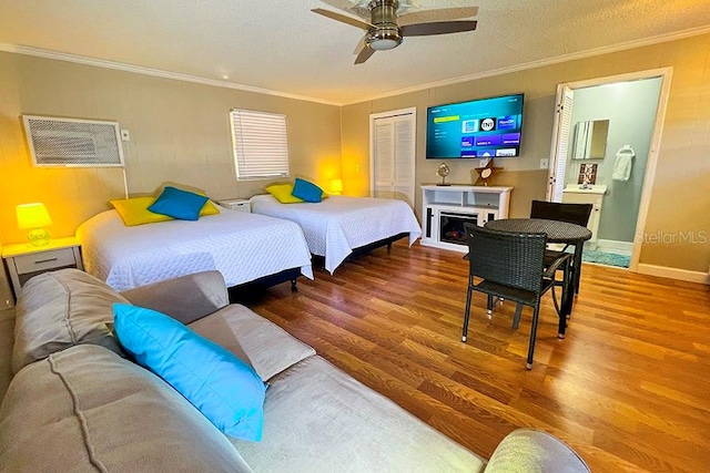 bedroom featuring crown molding, a textured ceiling, wood-type flooring, ceiling fan, and a closet