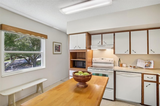 kitchen with a textured ceiling, white appliances, and white cabinetry