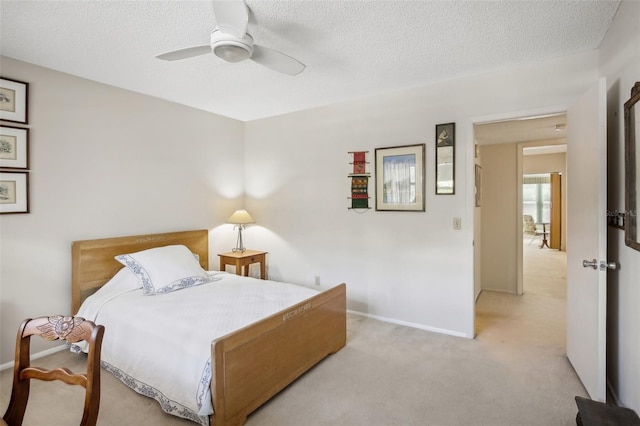 carpeted bedroom featuring ceiling fan and a textured ceiling