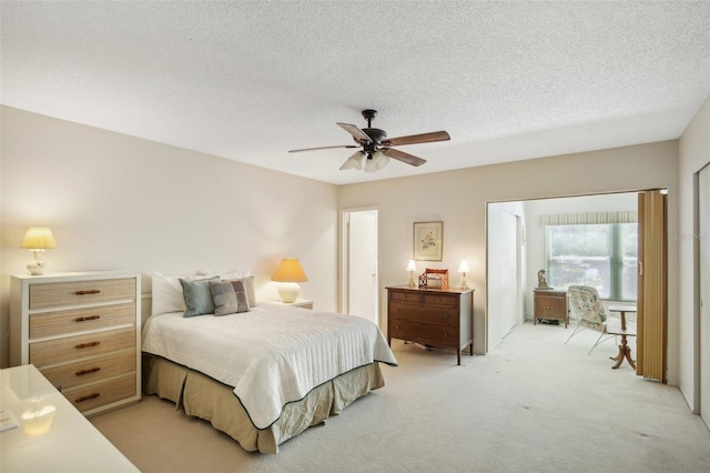 carpeted bedroom with a textured ceiling and ceiling fan