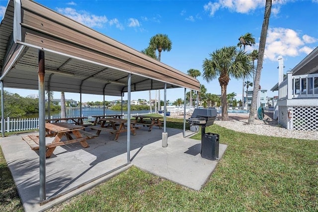 view of car parking featuring a water view and a yard