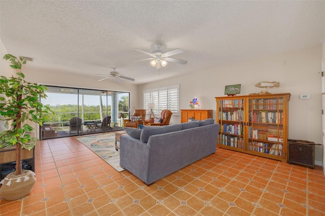 tiled living room with ceiling fan and a textured ceiling