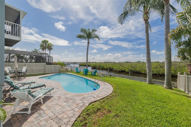 view of pool featuring glass enclosure, a water view, a patio area, and a lawn