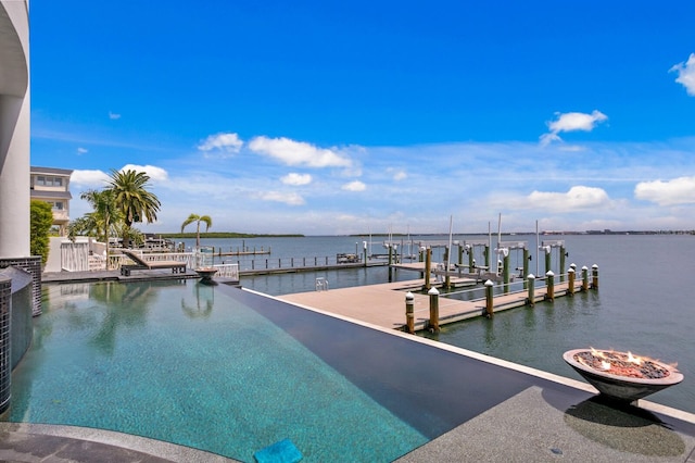 dock area with a fire pit and a water view