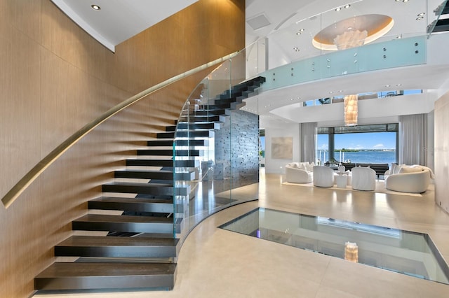 stairway featuring a high ceiling and tile patterned flooring