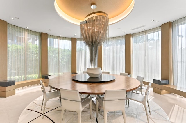 dining space featuring a tray ceiling and a chandelier