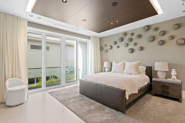 bedroom with a raised ceiling and access to outside