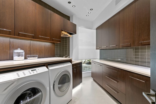 washroom featuring washing machine and clothes dryer and cabinets