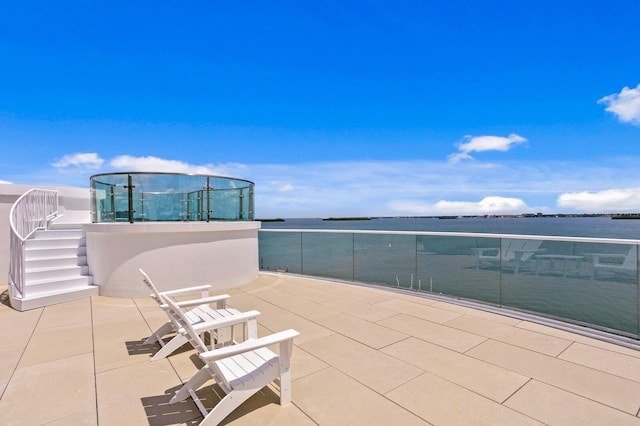 view of patio with a balcony and a water view