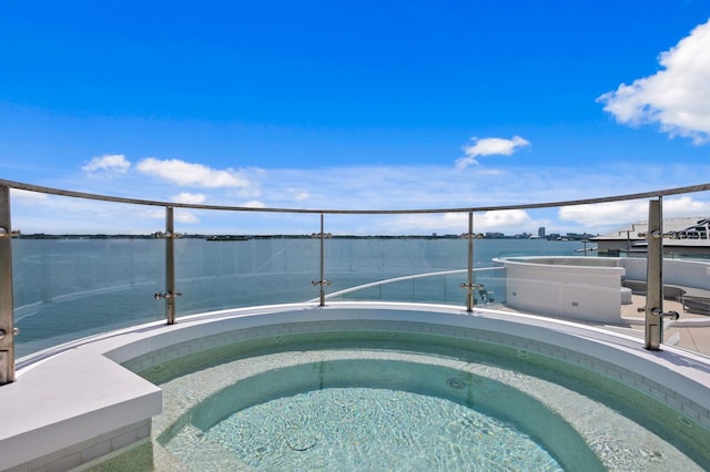 view of pool featuring a water view and a hot tub