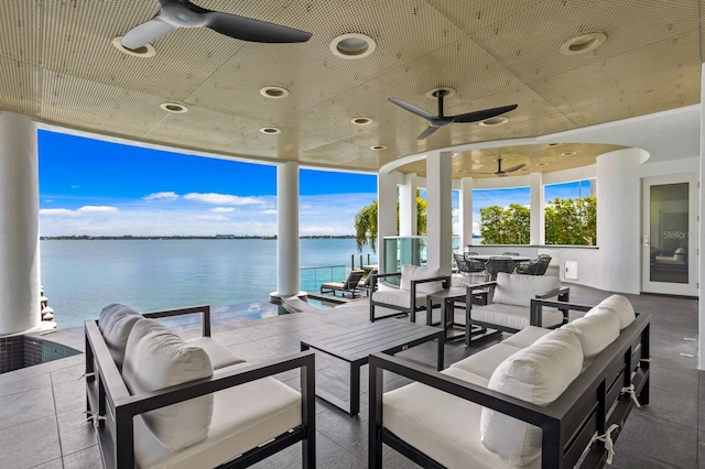 view of patio with outdoor lounge area, a water view, and ceiling fan