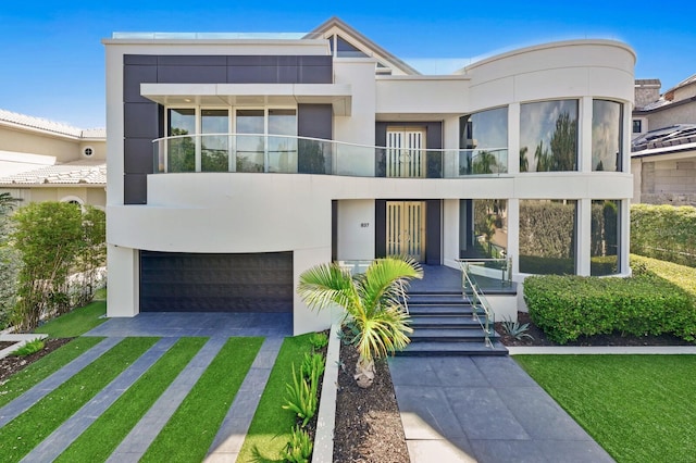 view of front of house featuring a balcony, a garage, and a front lawn