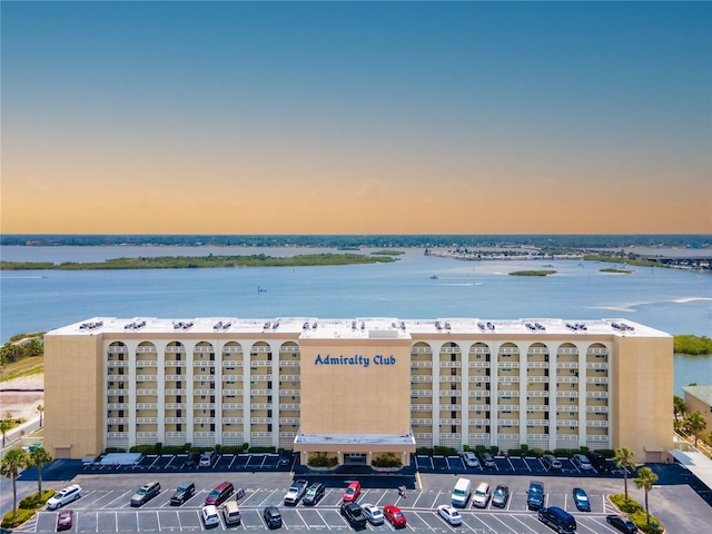 aerial view at dusk featuring a water view