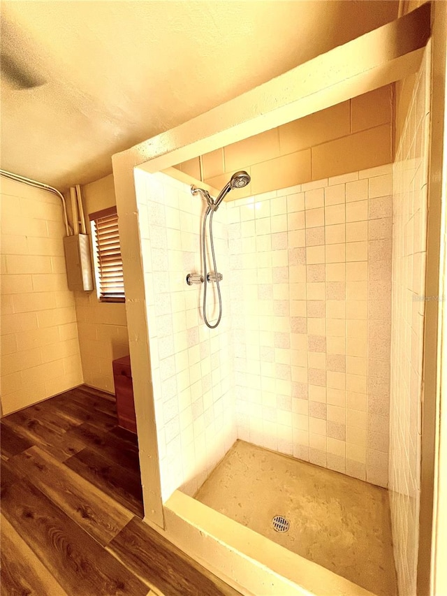 bathroom featuring wood-type flooring and tiled shower