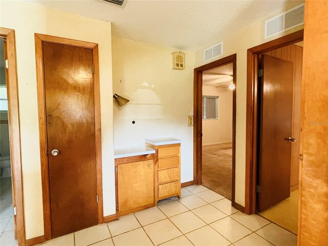 bathroom featuring a textured ceiling and tile patterned floors