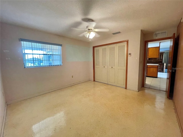 unfurnished bedroom featuring a textured ceiling, a closet, and ceiling fan